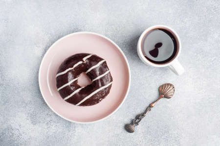 Donut in the glaze and a cup of coffee on the table. gray concrete table, copy spaceの写真素材