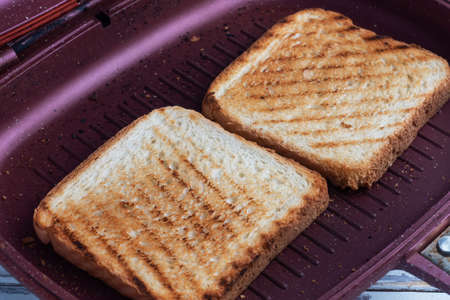 Two pieces of toasted bread in a grill pan. Close upの写真素材
