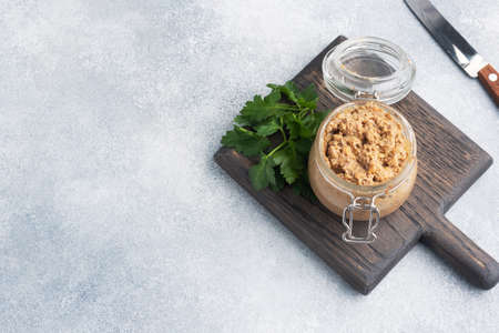 Homemade chicken liver pate in a glass jar on a gray concrete table. Copy spaceの写真素材
