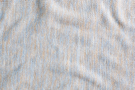Texture beige knitted wool, background textile material. Close up