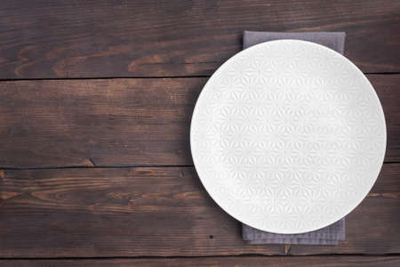 Empty white plate on wooden rustic tableの写真素材