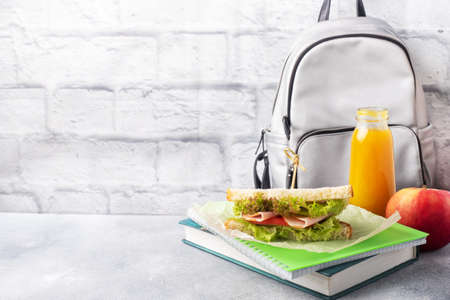 Snack for school with sandwich, fresh Apple and orange juice. Colorful school supplies Copy space,の写真素材