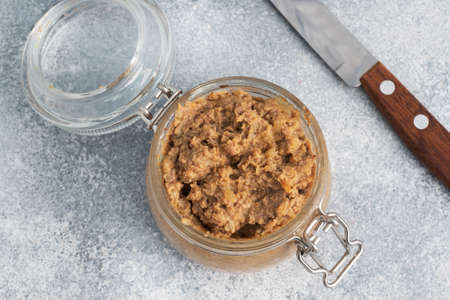 Homemade chicken liver pate in a glass jar on a gray concrete table. Copy spaceの写真素材