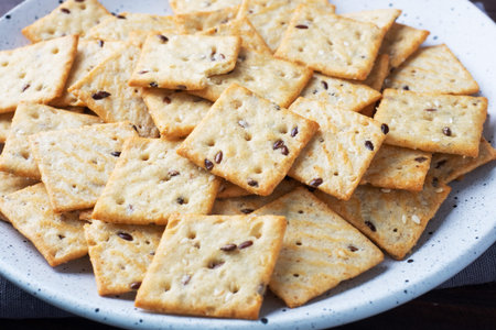 Delicious healthy cookies crackers with flax seeds and sesame seeds on a plate. Background of a healthy snack food, close upの写真素材