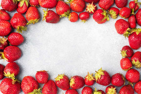 Frame Juicy ripe strawberries on a concrete background. Sweet healthy dessert, vitamin harvest. copy spaceの写真素材