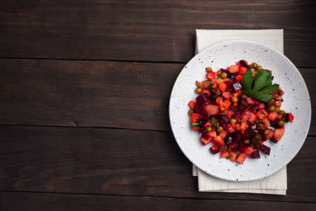 Vinaigrette with beetroot and boiled vegetables, traditional Russian homemade salad. Dark wooden background, copy spaceの写真素材