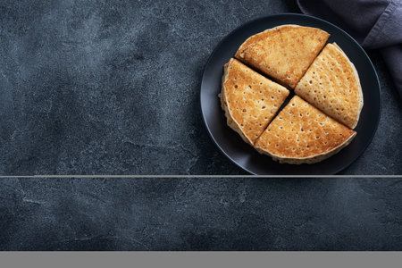 Pancakes with chocolate banana filling. Delicious breakfast of pancakes envelopes on a plate, dark concrete backgroundの写真素材