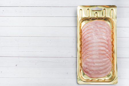 Pork ham in thin slices in a vacuum package on the table. Meat sliced carbonate in a package for...