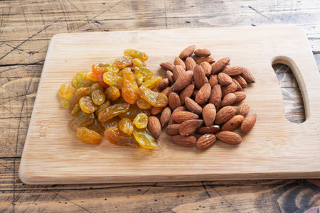 Raw nuts almonds and dried grapes raisins, concept healthy snackの写真素材
