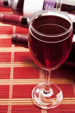 Glass of wine with bottles, stripped backgroundの写真素材