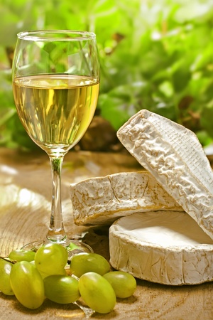 White wine, Brie, Camembert and grape on the wood surface, outdoorの写真素材