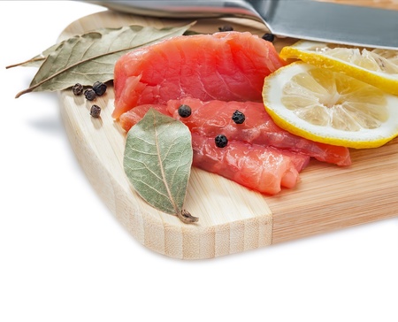 Salmon slices on the wooden board, isolated on white, studio shotの写真素材