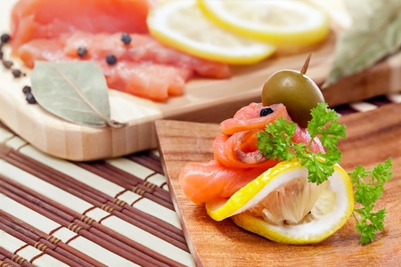 Salmon snack on the wooden plate, studio shotの写真素材