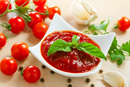 Red tomato sauce in a pan and ingredientsの写真素材
