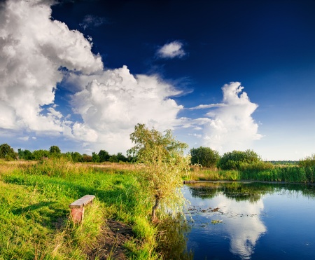 Landscape with lake and tree, cloudy skyの写真素材