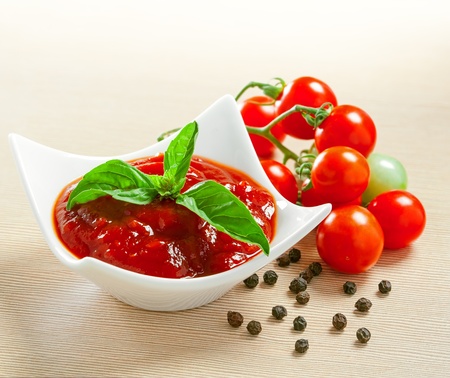 Red tomato sauce in a pan and ingredientsの写真素材