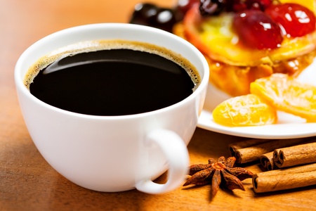 Cup of coffee and sweet fruit cake on a tableの写真素材