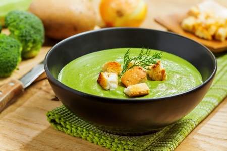 Broccoli cream soup and ingredients on tableの写真素材