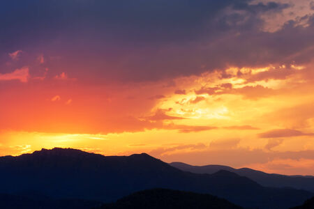 Cloudy sunset, landscape in mountainsの写真素材