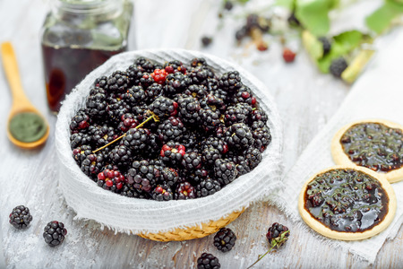 Fresh blackberries and biscuit sandwiches with jam on tableの写真素材