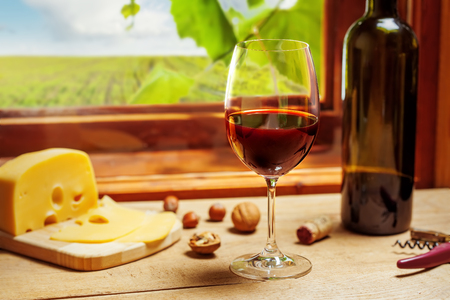 Red wine bottle and glass on wooden tableの写真素材