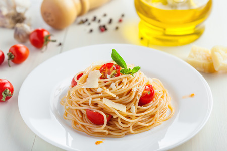 Italian spaghetti with tomato sauce, parmsesan cheese and basil on tableの写真素材