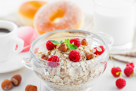 Healthy breakfast, oatmeal muesli on table with coffee and doughnuts.の写真素材