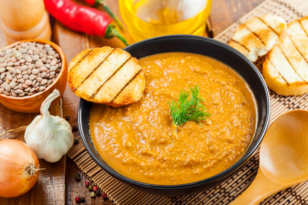 Cream soup made of lentil and vegetables on table with ingredients, healthy food, top viewの写真素材