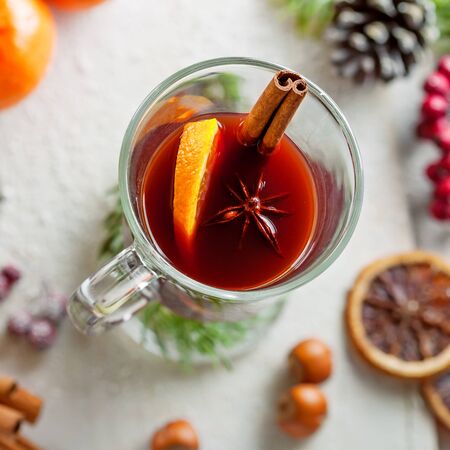 Glass of traditional hot drink on snow covered table. Red mulled wine.の写真素材