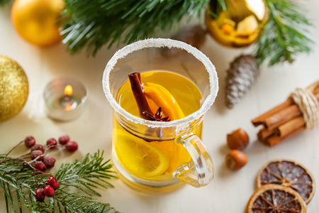 Holiday winter hot citrus drink near Christmas tree with decorations. Lemon tea. Top view.の写真素材