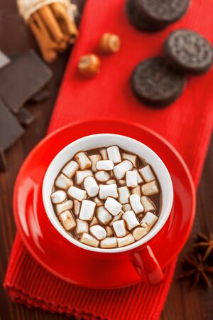 Cup of hot chocolate with marshmallow on table. Cocoa drink with sweet sandwich cookies.の写真素材