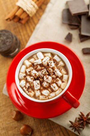 Cup of cocoa drink with marshmallow on table. Hot chocolate with sandwich cookies for breakfast.の写真素材