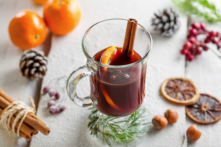 Traditional holiday winter hot drink. Mulled wine on snow covered table.の写真素材