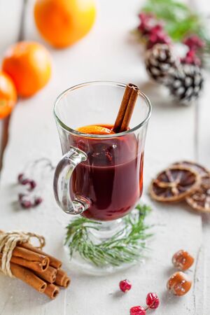 Mulled wine with fruits and spices on snow covered table.の写真素材