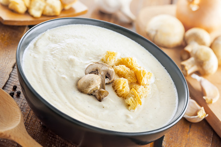 Mushroom cream soup on a brown wooden table, European foodの写真素材
