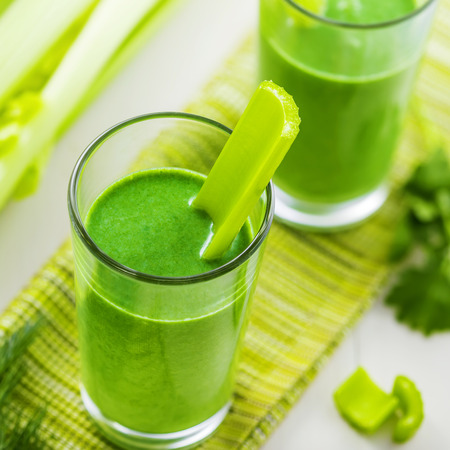 Glass of green smoothie on table, healthy vegetable drinkの写真素材