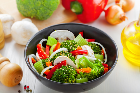 Salad in a bowl made of steamed broccoli, onion, mushroom, carrot and pepper.の写真素材