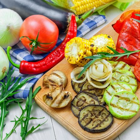 Set of grilled vegetables meal and ingredients: tomato, corn, eggplant, mushroom, bell pepper, marrow and onion. Healthy organic food on a table.の写真素材