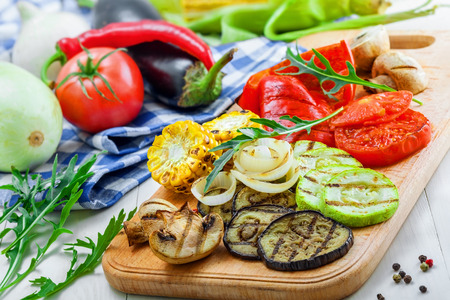Grilled vegetables: tomato, corn, eggplant, mushroom, bell pepper, marrow and onion. Delicious healthy food and ingredients on a table.の写真素材