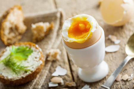 Breakfast with perfect soft boiled egg and sandwich with cheese. Traditional homemade food.の写真素材