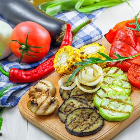 Grilled vegetables: tomato, corn, eggplant, mushroom, bell pepper, marrow and onion. Delicious healthy food and ingredients on a table.の写真素材