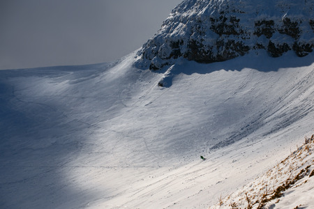 Freeride ski in deep powder snow of Carpathian mountains. Skier skiing downhill in winter mountains.の写真素材
