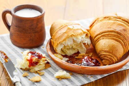 Delicious croissants with jam and milk for healthy breakfast. Traditional French healthy food.の写真素材