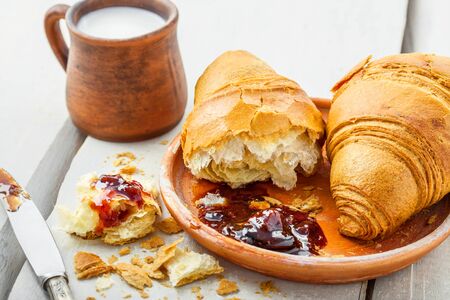 Delicious croissants with jam and milk for healthy breakfast. Traditional French healthy food.の写真素材