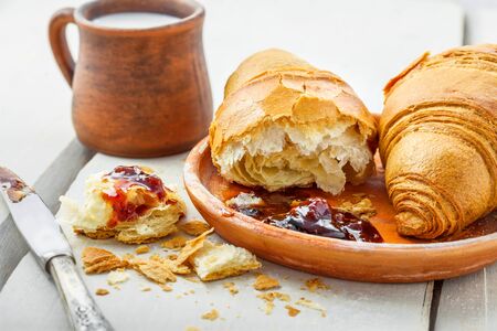 Croissant, jam and milk on a table. Traditional French healthy breakfast with croissants.の写真素材
