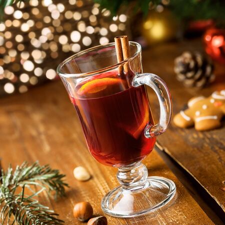Mulled wine with citrus fruits and cinnamon on a table. Traditional winter hot drink for Christmas Eve party.の写真素材