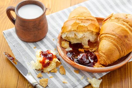 Croissant, jam and milk on a table. Traditional French healthy breakfast with croissants.の写真素材