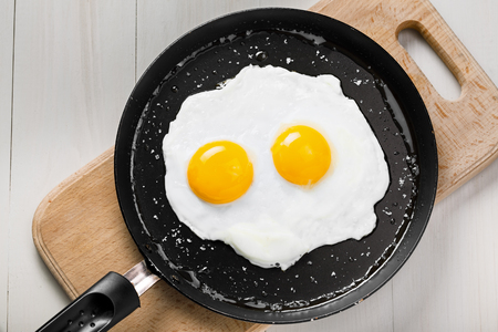 Fried eggs meal in a frying pan for delicious healthy breakfast. Traditional international breakfast food, top view.の写真素材
