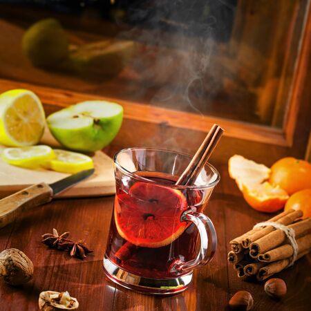Mulled wine for Christmas Eve celebration party on a table. Traditional winter Christmas drink near the window, winter landscape with sky full of stars on background.の写真素材