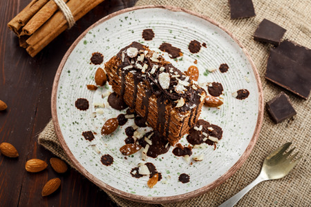 Slice of delicious chocolate Spartak cake on a rustic plate. First class dessert on a white wooden table. Top view.の写真素材